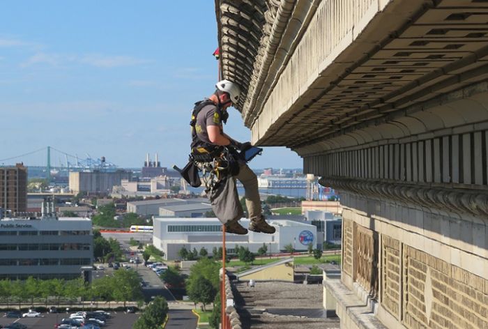 Structural Engineer | Facade Restoration | Victor Building | Camden, NJ | Side view of worker scaling building | O’Donnell & Naccarato