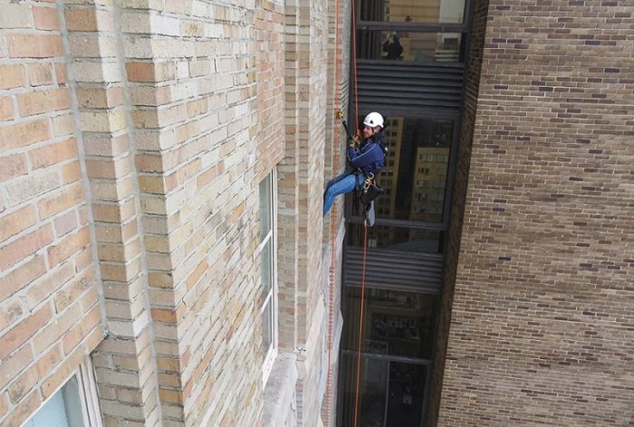 Structural Engineer | Facade Restoration | 1500 Walnut | Philadelphia, PA | Aerial shot of worker scaling building | O’Donnell & Naccarato